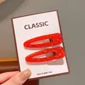 Set of two vibrant red acrylic teardrop hair clips with glitter finish on display card - Red Teardrop Clip