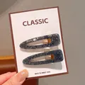 Pair of dark blue teardrop hair clips with silver glitter on a display card - Black Waterdrop Hair Clip