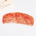 Peigne à cheveux avec texture marbrée orange et crème sur un fond blanc épuré - Orange