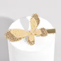 Golden butterfly hair clip with white pearls and champagne rhinestones on a white podium - Butterfly Pearl Rhinestone Style