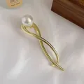 Elegant gold metal hair claw with large white pearl on textured white silk fabric - Pearl Gold