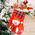 Red plaid Christmas stocking with 3D snowman hanging on a snowy tree branch - Christmas Snowman Style