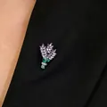 Eleganter Brosche-Blumenstrauß mit lila Kristallen und grünem Emaille-Stiel auf Anzug - Emaille-Strauß mit violetten Edelsteinen / Gold