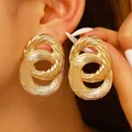 Large golden double-hoop earrings featuring intricate twisted rope texture - Interlocking Double Ring Twist Texture Style / Gold