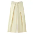 Detail view of high-waist cream wide-leg trousers featuring deep front pleats - Off White