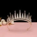 Dettaglio corona dorata con cristalli bianchi e neri su superficie rosa chiaro - Oro KC [Nero]