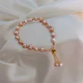 Nahaufnahme elegantes rosa Süßwasserperlen-Armband mit verstellbarem Goldverschluss - Rosa-Lila Perlen Verstellbarer Kordelzug-Stil (B1431#)