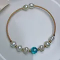 Detail view of 14K gold plated wire necklace with freshwater pearls and blue crystal - Gold Blue Cut Crystal Bead Style