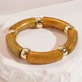 Elegant golden glitter acrylic segment bracelet featuring polished metallic gold beads on stone - Glitter Gold