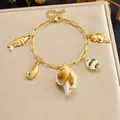 Gold-plated stainless steel charm bracelet with ocean-themed sea shell pendants. - Conch Seahorse Ocean Style (B2162)
