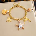 Gold-plated stainless steel beach bracelet with ocean-themed shell and dolphin charms - Dolphin Shell Ocean Style (B2167)