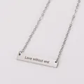 Détail d'un pendentif barre en acier inoxydable poli avec gravure Love without end. - Collier Barre Gravé / Acier
