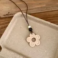 Detailed view of bohemian woven flower pendant necklace on natural stone tray - Flower Style (HN12219) / 1 Piece / Brown