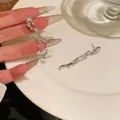 Dettaglio orecchini a nappa con zirconi a cuore su un piatto di porcellana bianca - Bottone Nappa (Perno Argento) / Argento