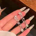 Close-up of silver heart fringe earrings with sparkling heart-shaped cubic zirconia stones - Silver Post Heart Waterdrop Tassel (HE33781) / Silver
