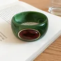 Detail view of a green marbled acrylic bangle featuring a large oval amber resin stone inlay - Green-Dark Coffee
