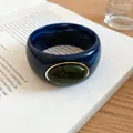 Close-up of blue acrylic bangle with green marble stone and elegant gold frame - Blue-Dark Green
