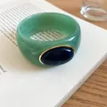 Close-up detail of the green marbled acrylic bangle with an elegant blue oval inlay design. - Light Green-Dark Blue