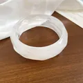 Dettaglio ravvicinato della trama marmorizzata di questo bracciale rigido a onde larghe - Trasparente
