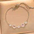 Close-up of heart-shaped pink stones and crystals on gold stainless steel bracelet - Gold (S1136)
