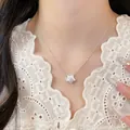 Minimalist silver-colored star pendant necklace with delicate chain on model. - Style 15