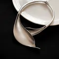 Vista dettagliata di un girocollo in metallo argento opaco con design a foglia - Argento Opaco