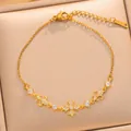 Detailed view of a gold-plated zirconia bracelet with a cross-flower motif on beige box - Cross Fleur-de-lis Style (S1127) / Gold