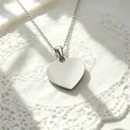 Detailopname van een gepolijste hartvormige hanger van roestvrij staal zilver - Ketting met hartjeshanger / Staalkleur