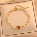 Detailansicht eines goldfarbenen Herzarmbands aus Titanstahl auf einer Schmuckschatulle - Europäische Büroklammer-Kette (728) / Rotes Muschelherz