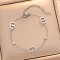 Vue rapprochée d'un bracelet en acier titane argenté avec des breloques en lettre D - Style (738) / Argent