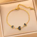 Gros plan d'un bracelet en acier titane doré avec cœurs en émail noir et cristaux - Chaîne de Cœur de Luxe (725) / Cœur de Coquille Noire Dorée (725)