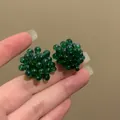 Detailed view of dark green beaded cluster earrings in a unique grape-like design. - Green