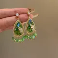 Macro view of vintage teardrop earrings featuring green crystals and resin flowers - Style 21# / Silver Earring Post - Gold - Green