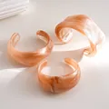 Close-up of three irregular geometric acrylic bangles with elegant amber marble texture - Three-Piece Set / Pink