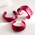 Set of three irregular red marble acrylic bangles shown in a minimalist still life arrangement - Three-Piece Set / Rose Red