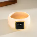 Detailed macro view of a retro acrylic bangle with black square inlay and gold trim - Square Style / Ivory And Black