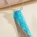Detail view of blue glass beads and silver chain tassel on a statement necklace - Blue