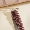Detailed view of silver safety pin necklace with long burgundy glass bead tassels - Brown