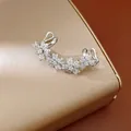 Primer plano detallado de un clip de oreja de flor de cristal en una caja dorada - Clip (Individual) / Plateado