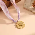 Macro detail of a golden sunflower pendant on a purple floral pattern silk scarf necklace. - Sunflower Full Flower Style (K808) / Gold with Purple Scarf