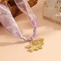 Macro view of golden sunflower pendant on a purple floral pattern scarf necklace. - Sunflower Half Flower Style (K808) / Gold with Purple Scarf