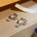 Detailed view of silver-finish hoop earrings featuring zircon butterfly and square charms - Silver