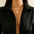 Layered golden CCB bead necklace with shell pendant and teardrop charms on model - Light Gold (Shell Style)