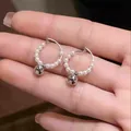 Detailed view of French-style hoop earrings with white pearls and silver ball pendant. - Hoop Dangle Style / Silver-White