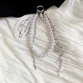 Detail view of a stylish pearl and chain keychain featuring heart and cross charms. - Pearl Heart Coin Pendant / Silver
