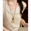 Close-up of a vintage ethnic woven long necklace with a bohemian flower pendant. - Five-Petal Flower Pendant Style (HN12227) / Brown