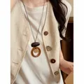 Close-up of vintage ethnic woven long necklace with circular pendant on linen vest - Round Ring Pendant Style (HN12225) / Brown