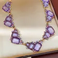 Primo piano della collana vintage con gemme viola e cristalli rosa e blu scintillanti - Oro-Viola