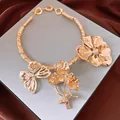 Dettaglio di un girocollo dorato vintage con grandi motivi di fiori e farfalle in metallo - Collana choker / Oro