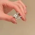 Vue détaillée de bagues argentées élégantes avec motif floral en nacre blanche. - Ensemble deux pièces / Argent